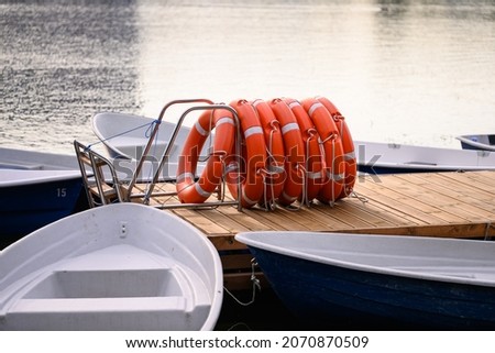 Pier with Lifebuoy and boats . Boat for walking. Boat rental. Relax in the summer. Outdoor recreation.