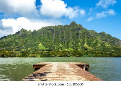 A pier on Molii Fishpond looking toward the Koolau Mountain Range at Kualoa Ranch on Oahu, Hawaii
