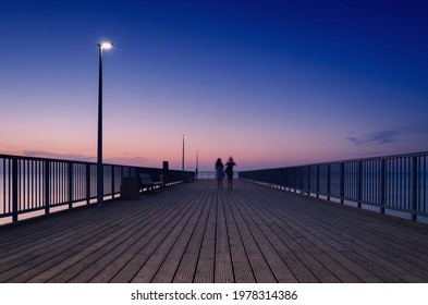 PIER ON THE SEA COAST - Womens walk at a quiet sunset 