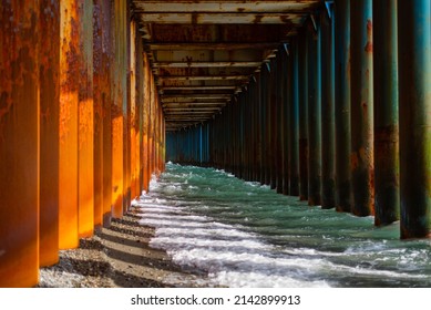 pier piles under the bridge go into the sea. sunny day hard shadows. - Shutterstock ID 2142899913