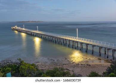 Pier at sunset blue hour Point Lonsdale.  Located near The Rip entrance to Port Phillip Bay Victoria, Australia.  Featuring the pier lights reflecting in the water