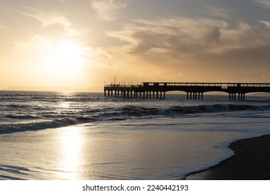 Pier At Sunset With Waves Breaking