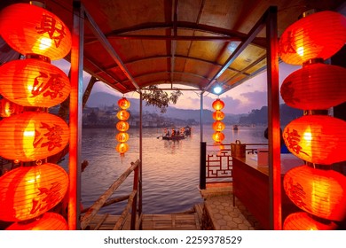 The Pier for tourists to ride chiness boats on the lake at Ban Rak Thai village, Mae Hong Son province, Thailand. Chinese characters on red lantern - Translated text means happy, lucky, wealthy - Shutterstock ID 2259378529