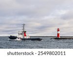 Pier with tower and tugboat on shore of the Baltic Sea in Warnemuende, Germany.