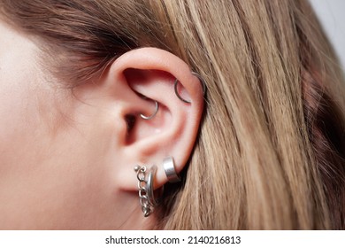 Piercings On An Ear. Conch And Helix Piercings Close Up.