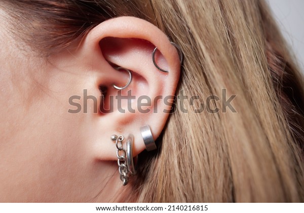 piercings\
on an ear. Conch and helix piercings close\
up.