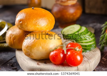 pies, loaf bread, dough on a wooden vintage cutting board old rustic, mustard sauce-dish, tomato, greens, black pepper gherkins, cucumbers, on the table top, side, bottom shot angle, fork and knife