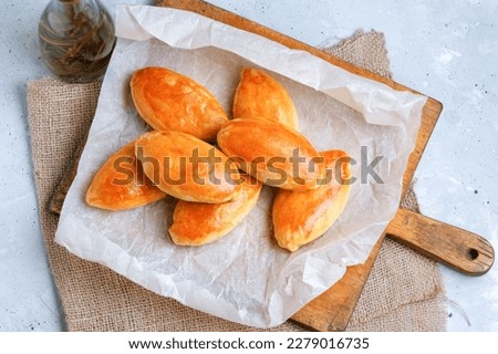 Pies (Patties, Pirozhki) With Filling On Baking Papper Background. Flat Lay.