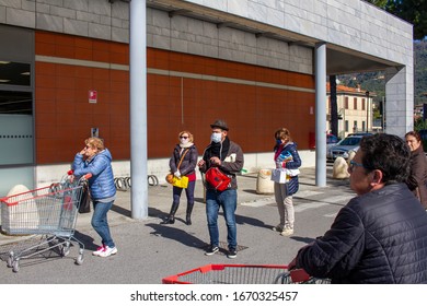 Pietrasanta, Lucca/Italy - Mar 11 2020 : Coronavirus In Italy, People Lined Up Waiting For Their Turn To Enter To The Supermarket