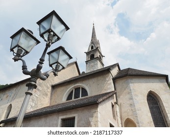 Pieve Tesino, Italy. Santa Maria Assunta gothic church. 12th century building remodeled in the 15th century. Church, bell tower and vintage street lamp. Photo taken from below. - Powered by Shutterstock