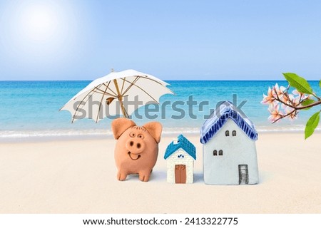 Pig clay sculpture with miniature house on tropical beach, property investment, house loand