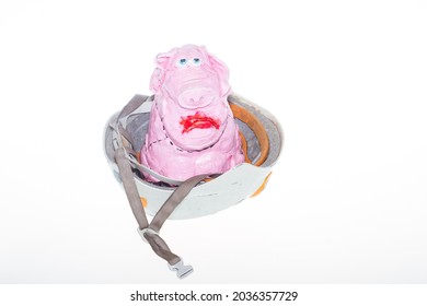 A Pig In A Helmet. A Piglet In A Helmet On A White Background. The Pink Pig Has Sad Eyes.