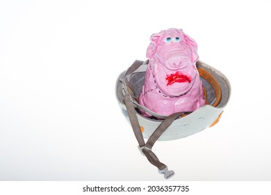 A Pig In A Helmet. A Piglet In A Helmet On A White Background. The Pink Pig Has Sad Eyes.