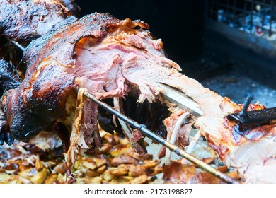 Pig roasted on a barbecue spit. Outdoor Barbecue grill a classic traditional open bbq pit. Steaks and meat cooked on a wood fire grill. Selective focus