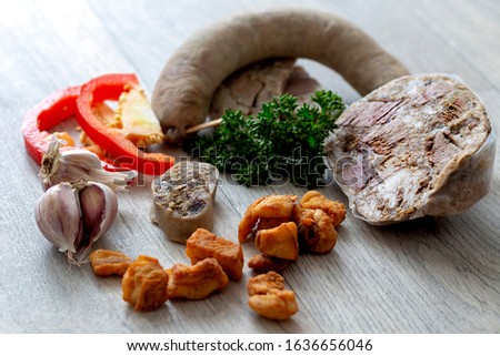 Pig slaughtering products - brawn, sausages, greaves, garlic, slices of red pepper and green parsley