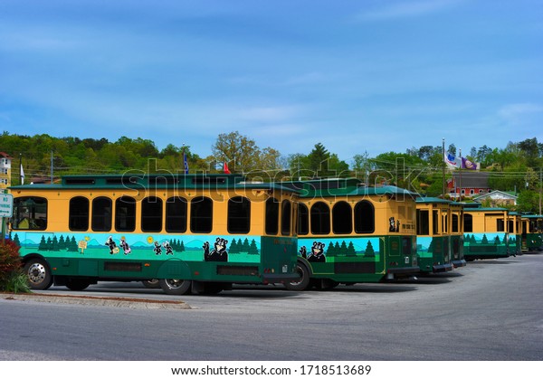 Pigeon Forge, Tennessee, USA - April\
22,2020:  Trolly cars sit in a parking lot during the coronavirus\
pandemic as people are ordered to shelter in\
place.