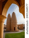 Pigeon towers of the Katara cultural village in Doha, Qatar framed through an arch. Katara is located on the eastern coast between the West Bay District and The Pearl-Qatar