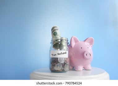 Piggy ban with Tax Refund label on a coin jar                              