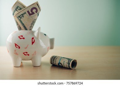 piggy bank and American dollar banknote on wooden table. Investment and money Saving for the future concept - Shutterstock ID 757869724