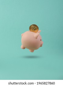 Piggy bank with bitcoin floating on blue background. 3D photo. Concept art. Minimalism