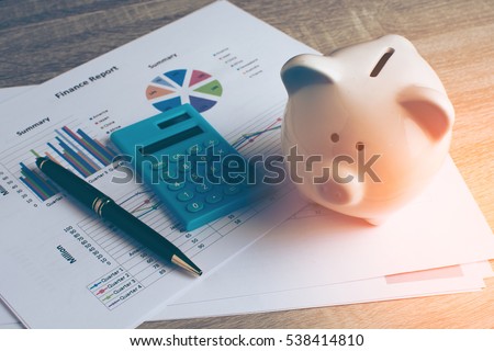 Piggy bank with business stuff, business and finance concept, vintage color tone.