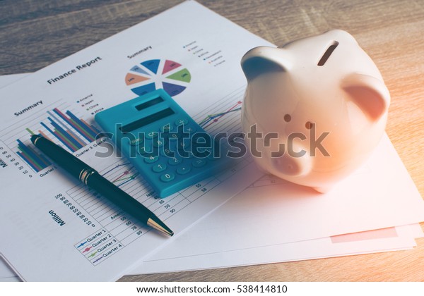 Piggy bank with business stuff, business and finance concept, vintage color tone.