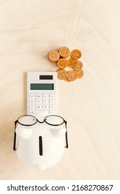 Piggy Bank And Calculator And Stack Gold Coin Put On The Wood In The Office, Saving Money And Loan For Business Investment Concept.