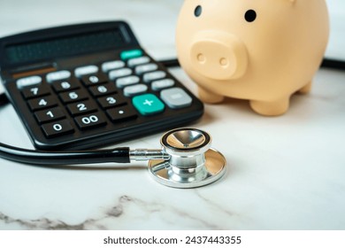 A piggy bank with a calculator and stethoscope showcases the financial aspect of healthcare. - Powered by Shutterstock