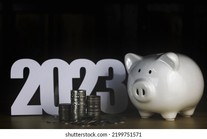 Piggy Bank With Coin And 2023 Text On The Wood Table.Set Financial Goals Concept.