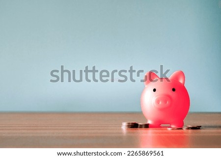 Piggy Bank and a few coins on gray background. The concept of saving less saving money piggy bank and financial planning concept, broke and poor copy space