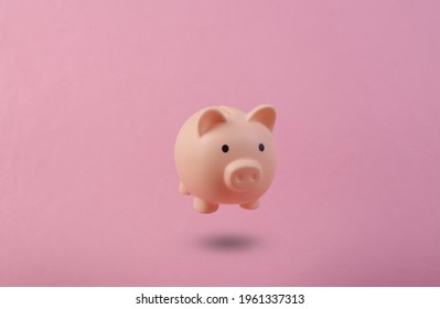 Piggy bank floating on blue background. 3D photo. Concept art. Minimalism