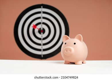 piggy bank in front of dartboard concept of saving money with a goal
