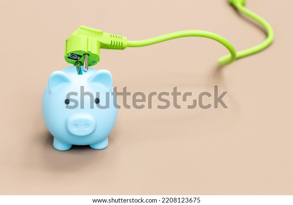 Piggy\
bank and green electric cable, Environmental concept promoting\
natural and economical sources of energy, Modern technologies of\
obtaining green energy, place for an\
inscription
