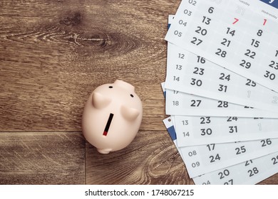 Schweine Bank mit monatlichem Kalender auf Holzboden. Monatliches Budget. Draufsicht