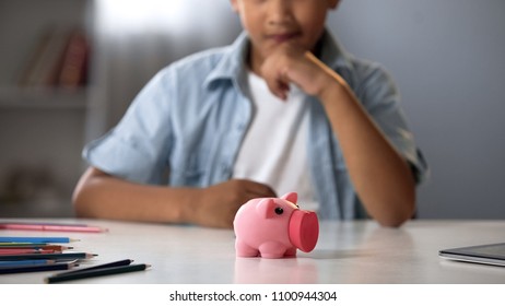 Piggy bank on table in front school boy, planning budget, pocket money, finance