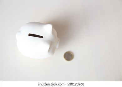 Piggy Bank on a white background. Saving money concept. Saving, putting a coin into piggy bank. EUR. EURO.  - Shutterstock ID 530198968