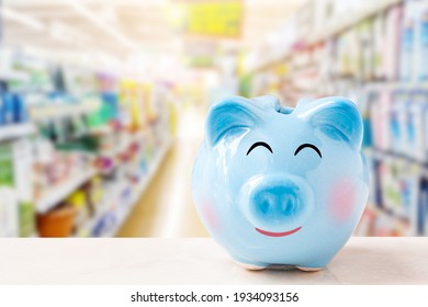 piggy bank on wooden table over supermarket or shopping mall background.
