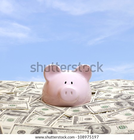 Piggy bank in a pile of dollars