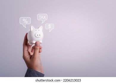 Piggy Bank Property Tax, Local Development Tax Concept. Word Tax, Man Holding Piggy Bank With Money,tax And Percent Icon. US Dollar Bags On A Table, Depicts Ad Valorem Tax On Value Of A Property.