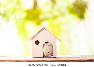 Piggy bank put in the wooden home model put on the wood on nature bokeh in the public park, Loan or save money for buy a house and real estate concept - Shutterstock ID 2367027813