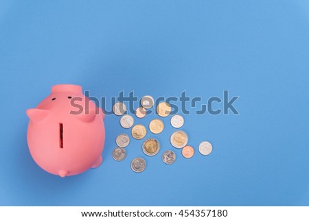 piggy bank save coin, blue desk background, top view.