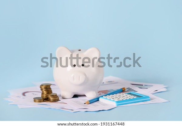 Piggy bank with savings, calculator\
and documents on color background. Concept of\
pension