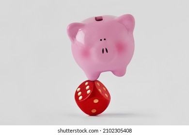 Piggy bank standing balanced on red dice - Concept of economy and financial risk