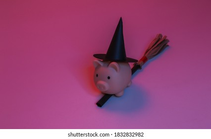 Piggy bank in a witch's hat on a broomstick. Red-blue gradient neon light. Halloween theme - Powered by Shutterstock