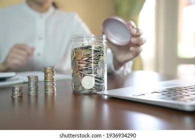 Piggy Bank. Woman At The Background. Home Setting. Savings For Retirement Or Rainy Days Concept.