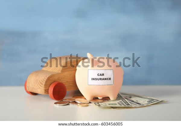 Piggy bank with wooden\
toy car on table