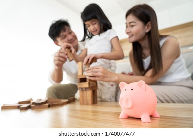 Piggy Coin Save Money Bank With Asian Family With Kids Happy To Play Building Wooden Blocks Home Together On Background, Property Investment And House Mortgage Financial Debt Plan Concept