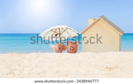 Piggy and elephant clay sculpture with miniature house on tropical beach, property investment, house loan