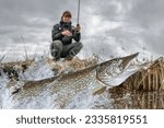 Pike fishing. Fisherman catch big muskie fish splashing in water