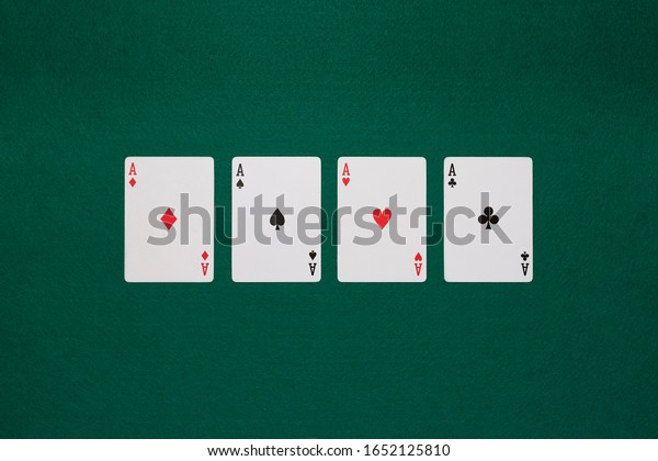 pikes card, cloves card, tiles card and hearts card\
on poker table green